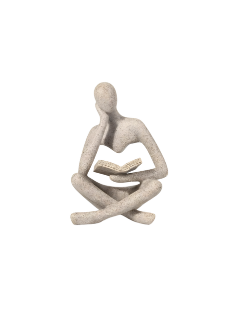 Statue of a person sitting and reading a book on a white background