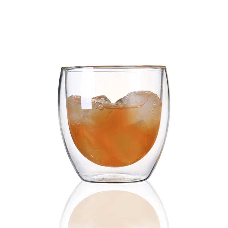 Clear glass with a drink and ice cubes on a white background
