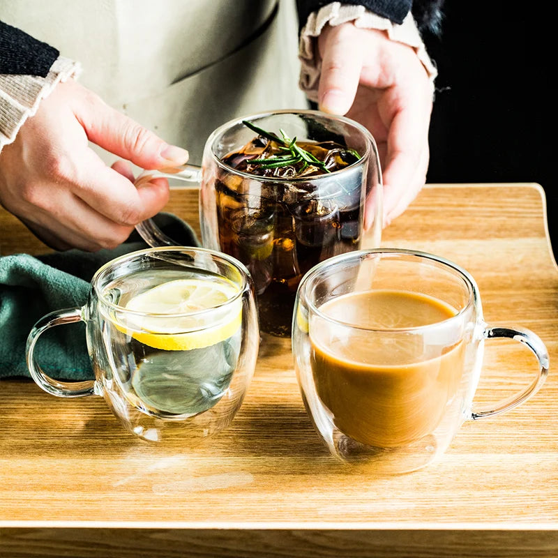 Three glass cups with different beverages on a wooden surface.