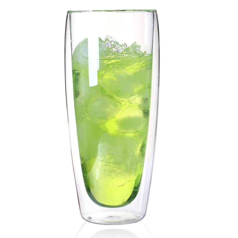 Clear glass filled with green iced drink on a white background