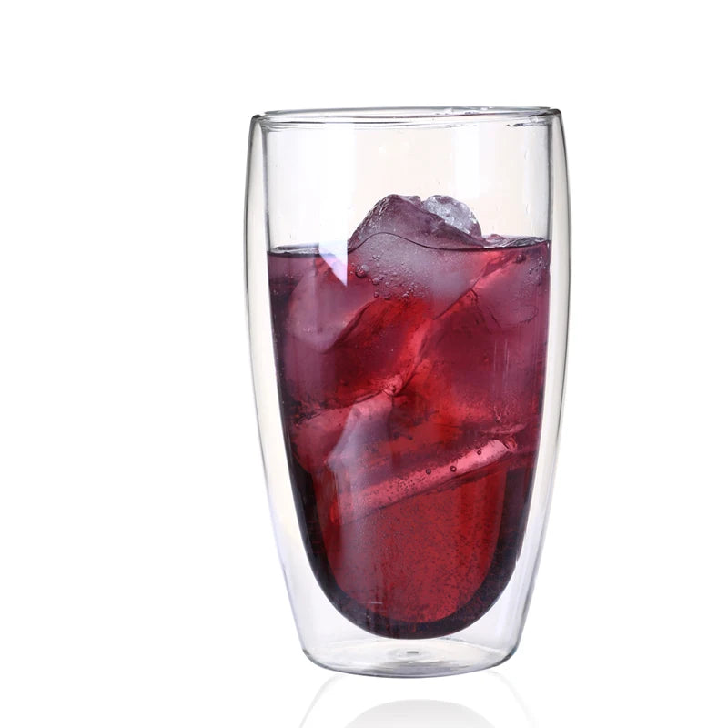 Clear glass tumbler filled with red liquid and ice cubes on a white background