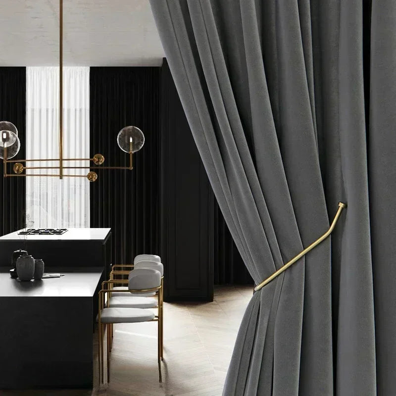 Modern interior with gray curtains, white chairs, and a kitchen area.