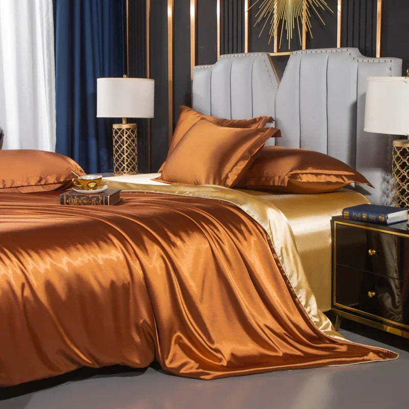 Bedroom with gold satin bedding and decorative pillows.