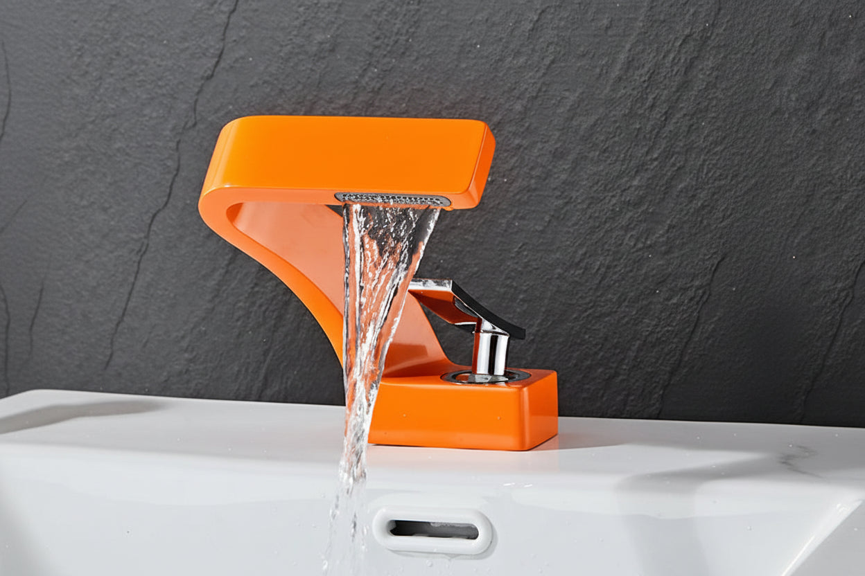 Orange basin faucet with water flowing against a dark stone background, featuring the brand 'TOLM'.