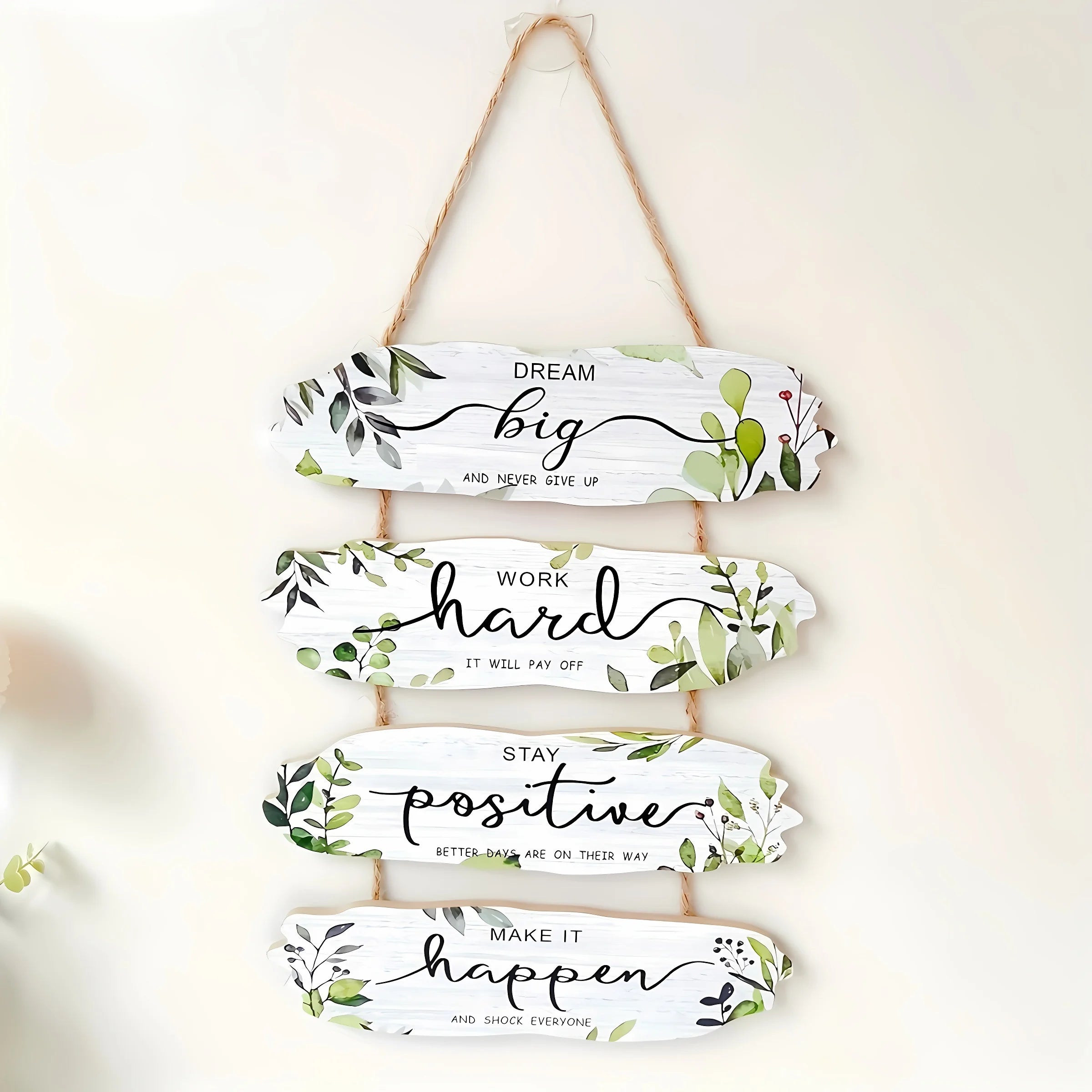 Decorative wall hanging with motivational phrases and floral designs on a white background