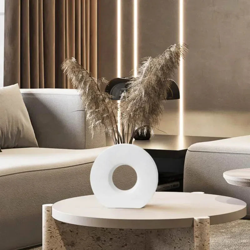 Modern living room with a round coffee table, decorative vase, and pampas grass.