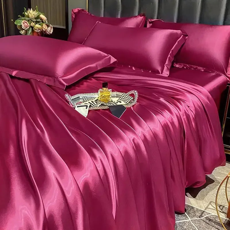 Magenta satin bedding set on a bed with decorative items.
