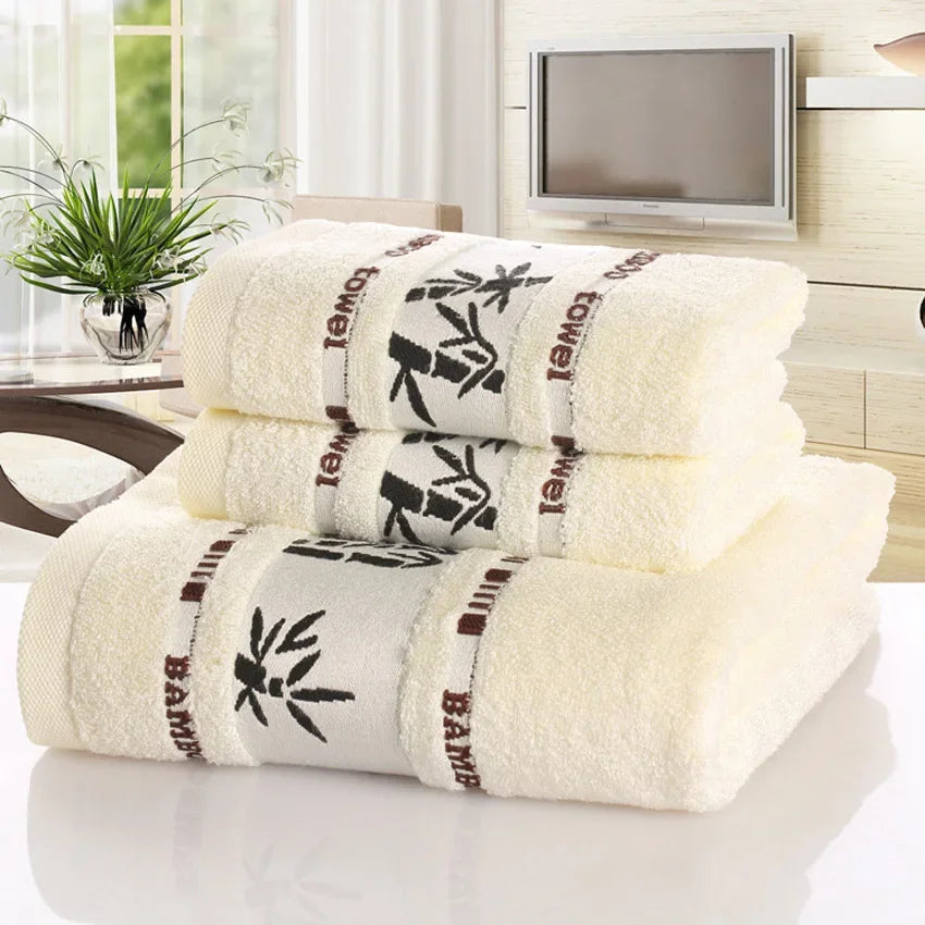 Stack of white towels with black and red text and patterns on a white surface.