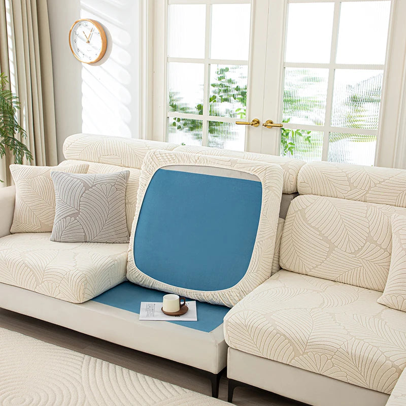 Beige sectional sofa with a blue cushion on a white rug in a bright living room.