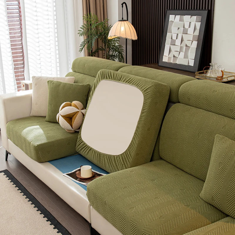 Green sofa with decorative pillows in a living room setting