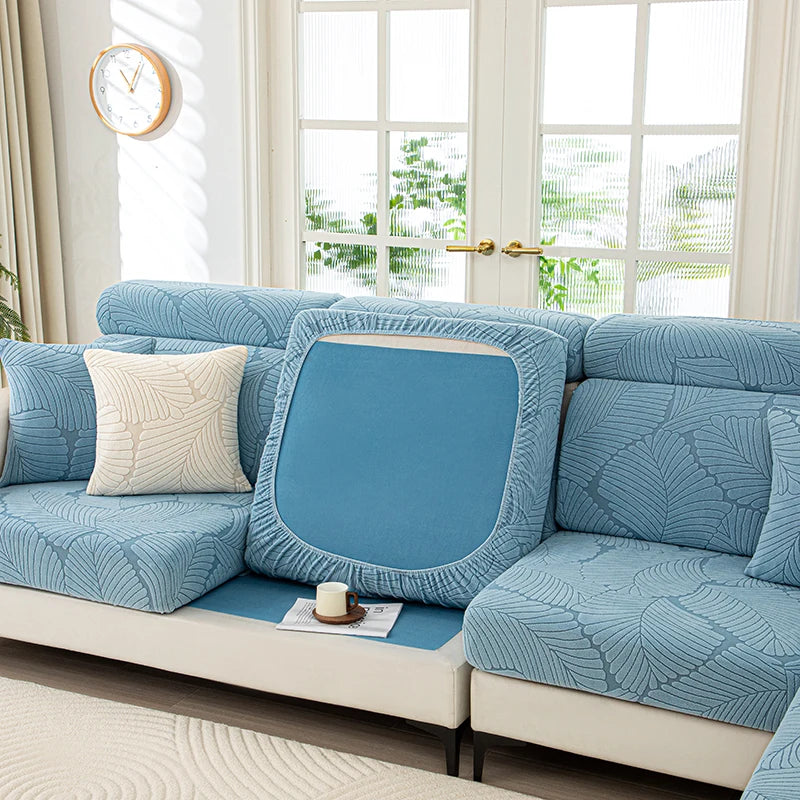 Blue textured sofa cover on a sectional sofa with a decorative pillow in a bright living room.