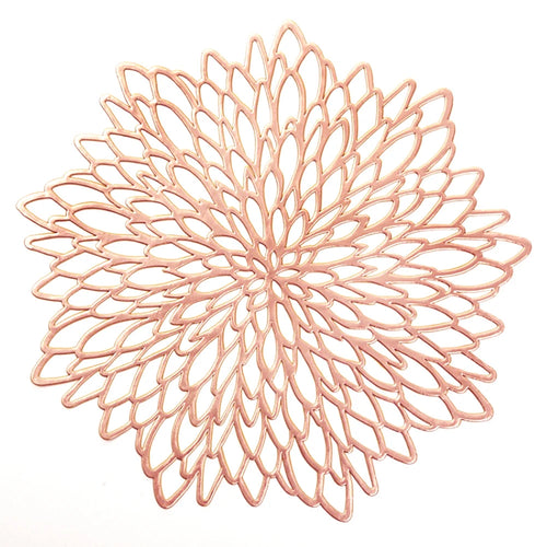 Decorative rose gold metal trivet on a white background