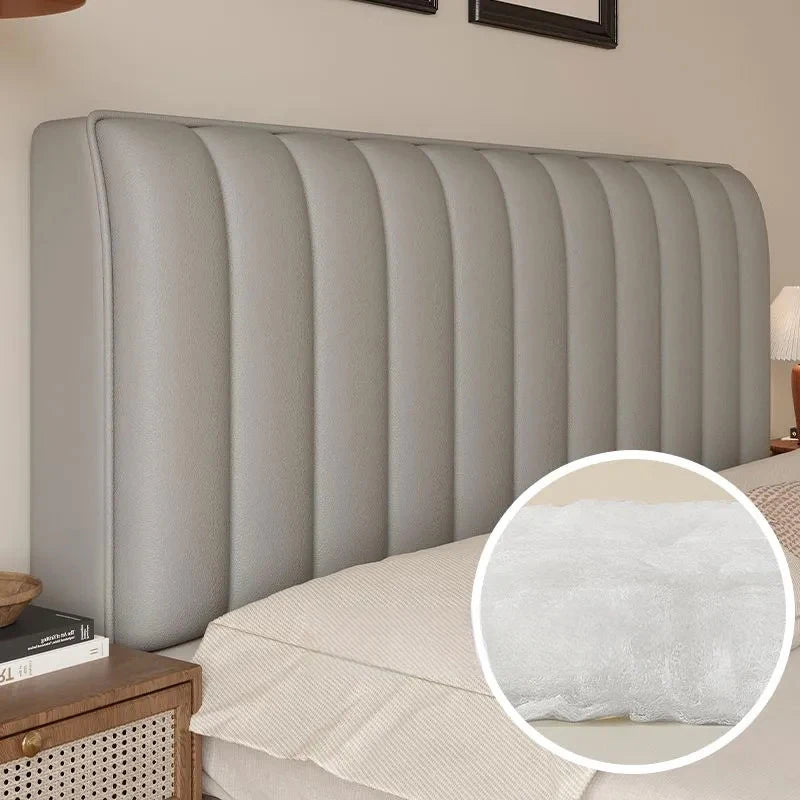 Gray upholstered headboard with a close-up of the fabric texture on a bed.