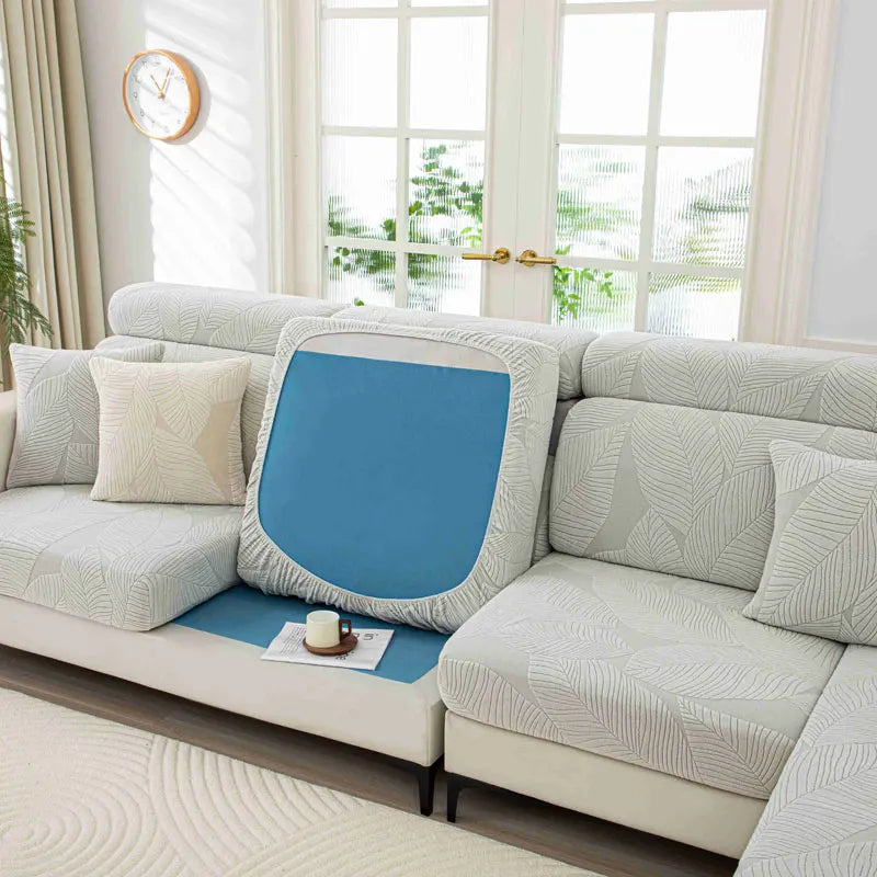 Sectional sofa with a blue cushion and a small table in a bright living room.