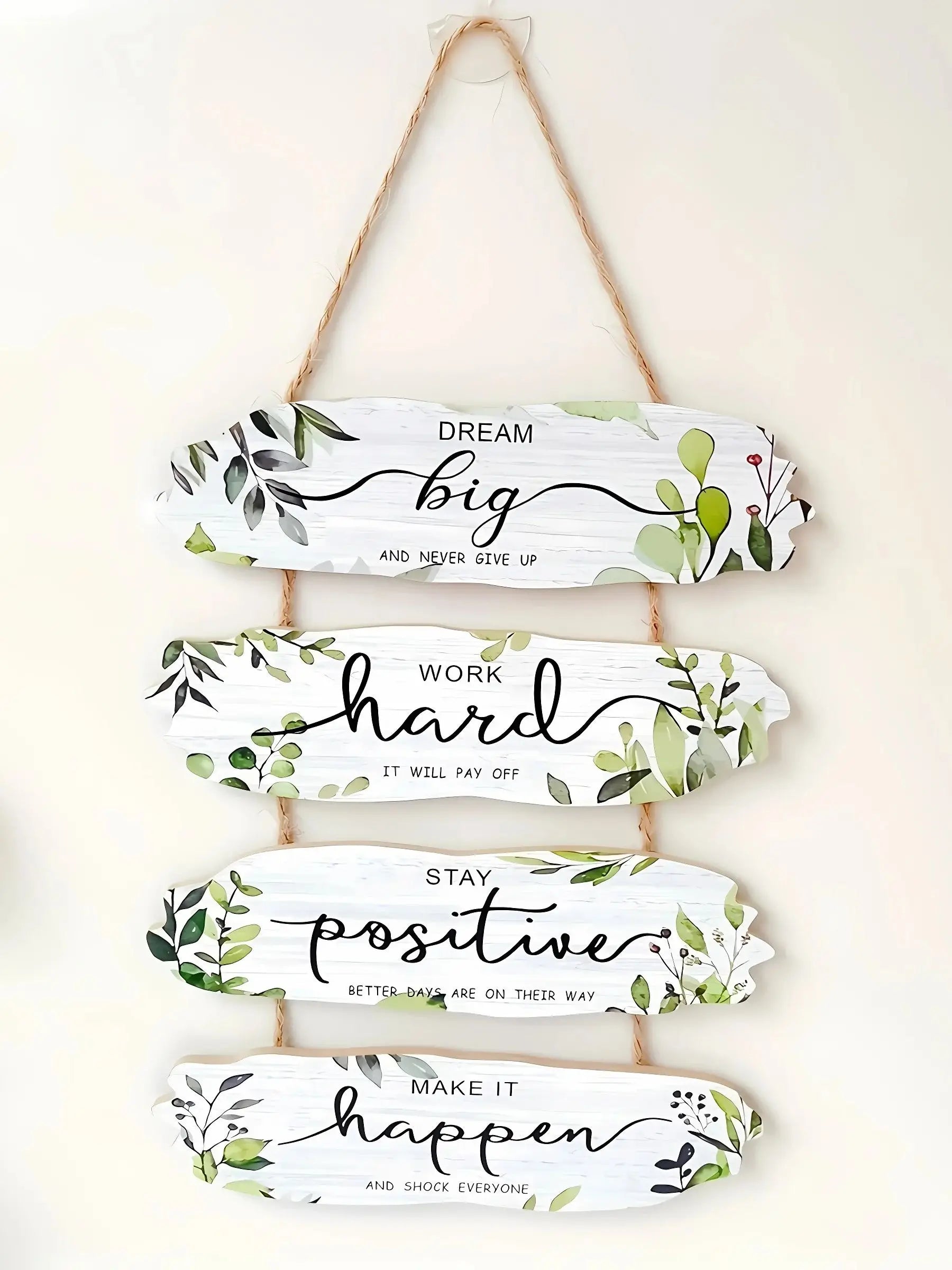 Decorative wall hanging with motivational phrases and leaf designs on a white background