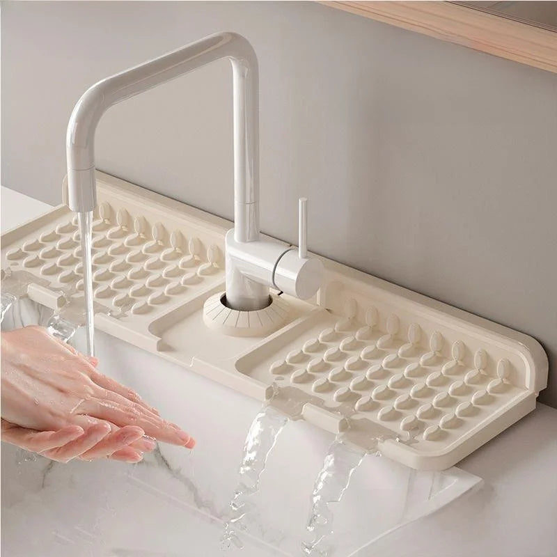 Beige kitchen sink drain board with faucet over a white sink