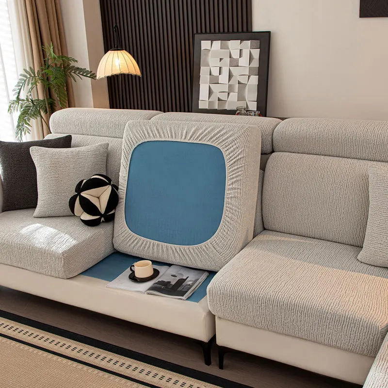 Gray sectional sofa with decorative pillows and a blue cushion in a living room setting.