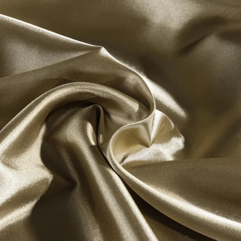 Close-up of beige satin fabric with folds