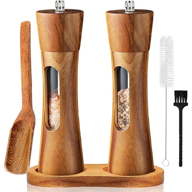 Wooden salt and pepper grinder set with a brush and scoop on a white background