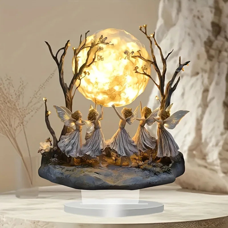Decorative lamp with fairy figures and a glowing moon-like sphere on a neutral background