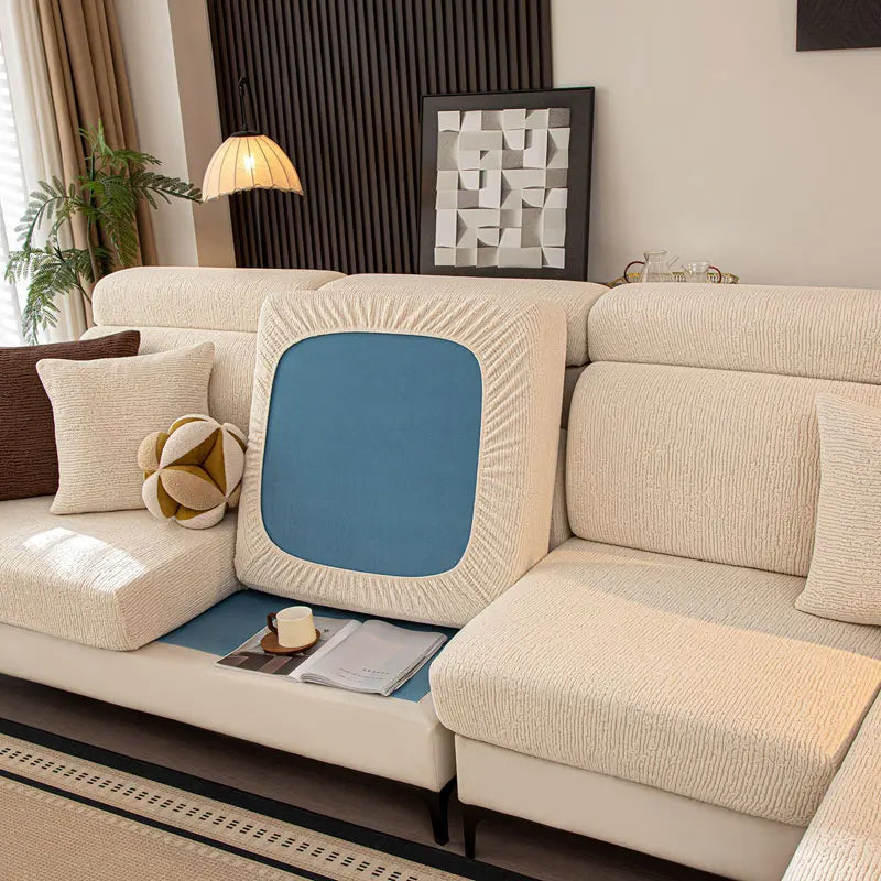 Beige sectional sofa with decorative pillows and a blue cushion in a living room setting.