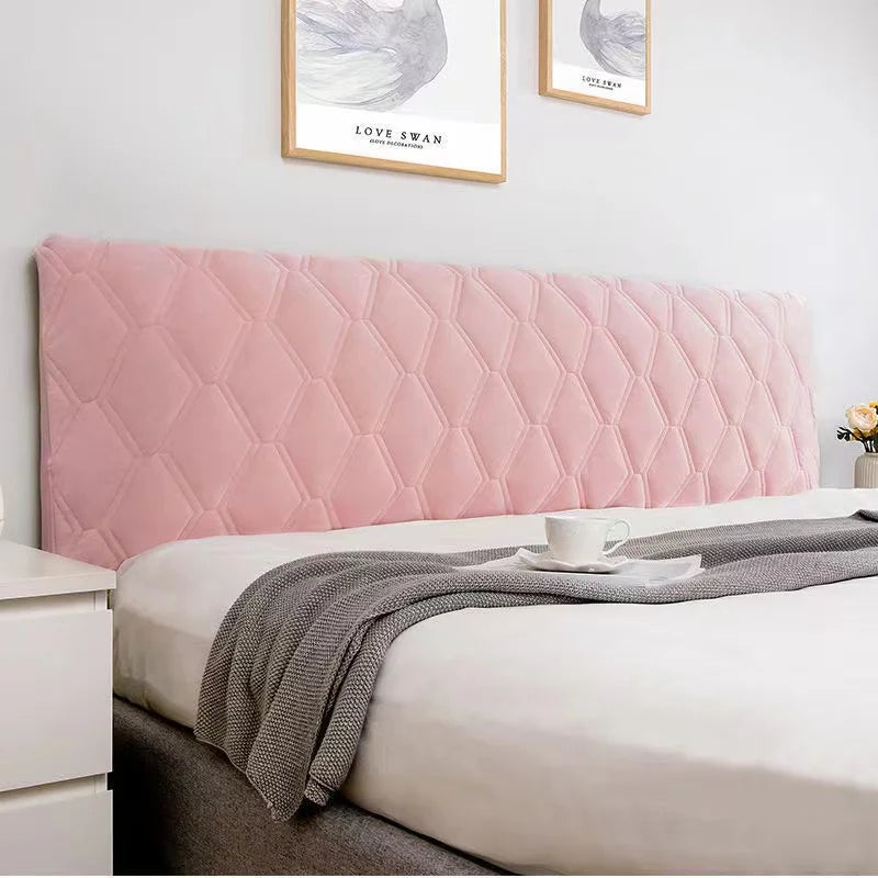 Bedroom with a pink quilted headboard and white bedding.