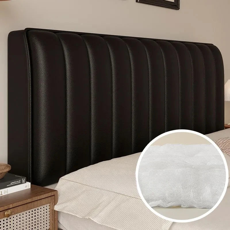 Black upholstered headboard with a close-up of the cushioning on a bed.