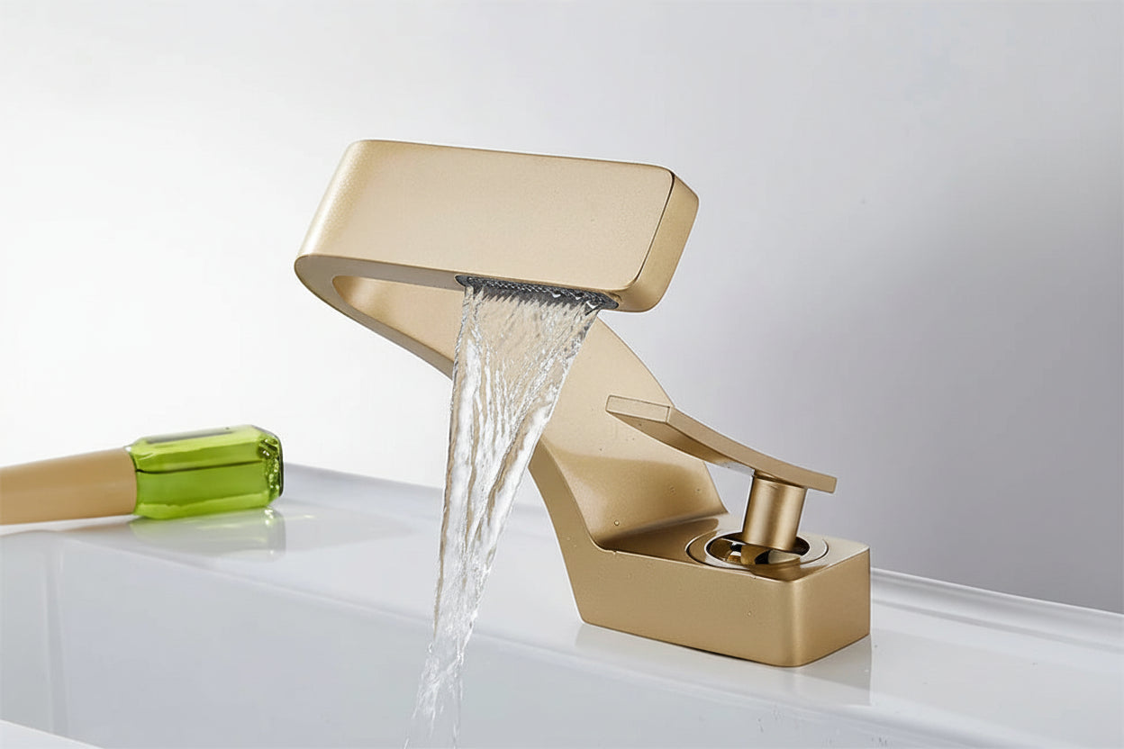 Gold waterfall faucet with water flowing, brand 'TOLM' visible