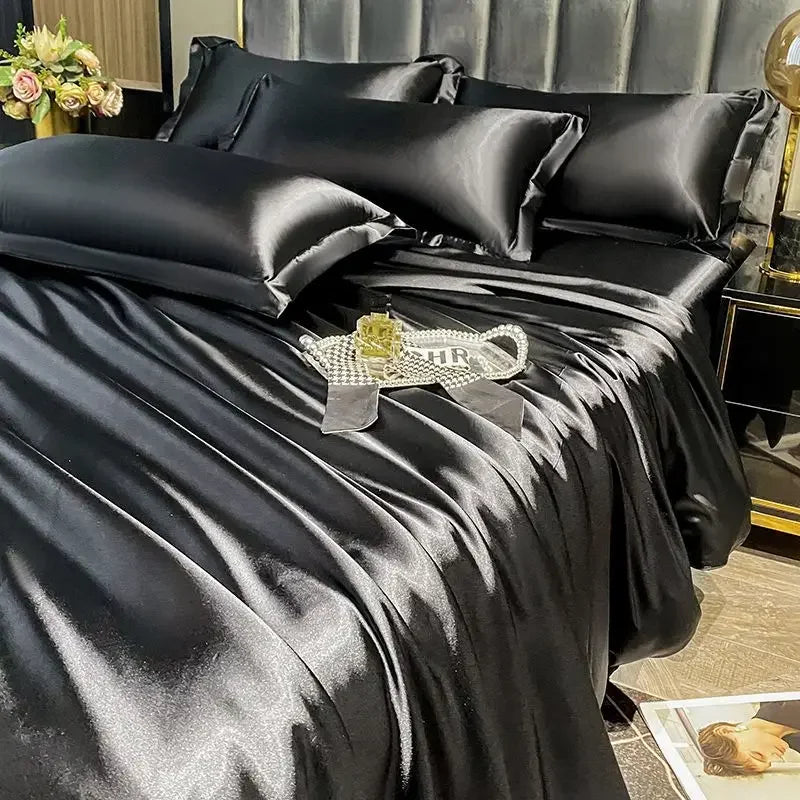 Black satin bedding set on a bed with decorative items.