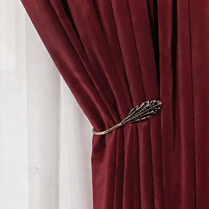 Red curtain with decorative gold tieback against a white background