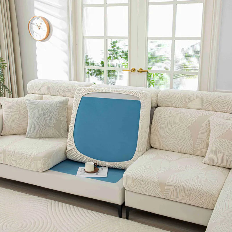 Blue cushion on a beige sofa in a bright living room with large windows.
