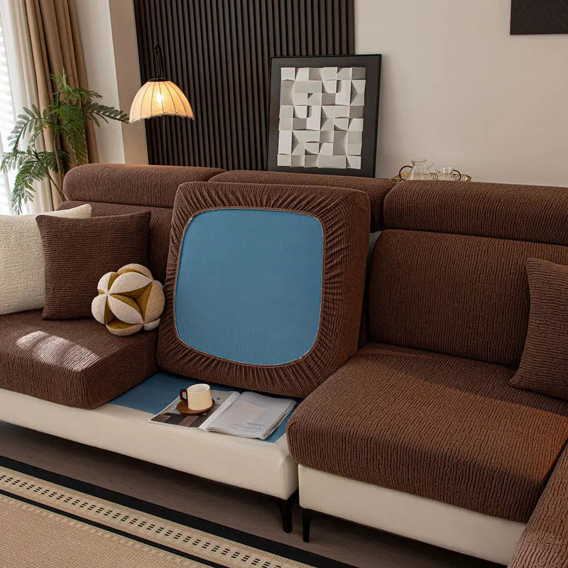 Brown sectional sofa with a blue cushion in a living room setting.