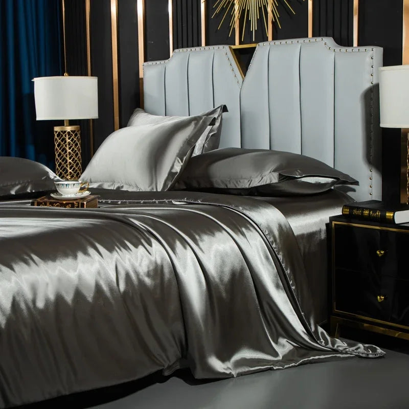 Gray satin bedding set on a bed with matching headboard and nightstands.