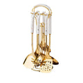 Set of gold kitchen utensils with white handles on a white background