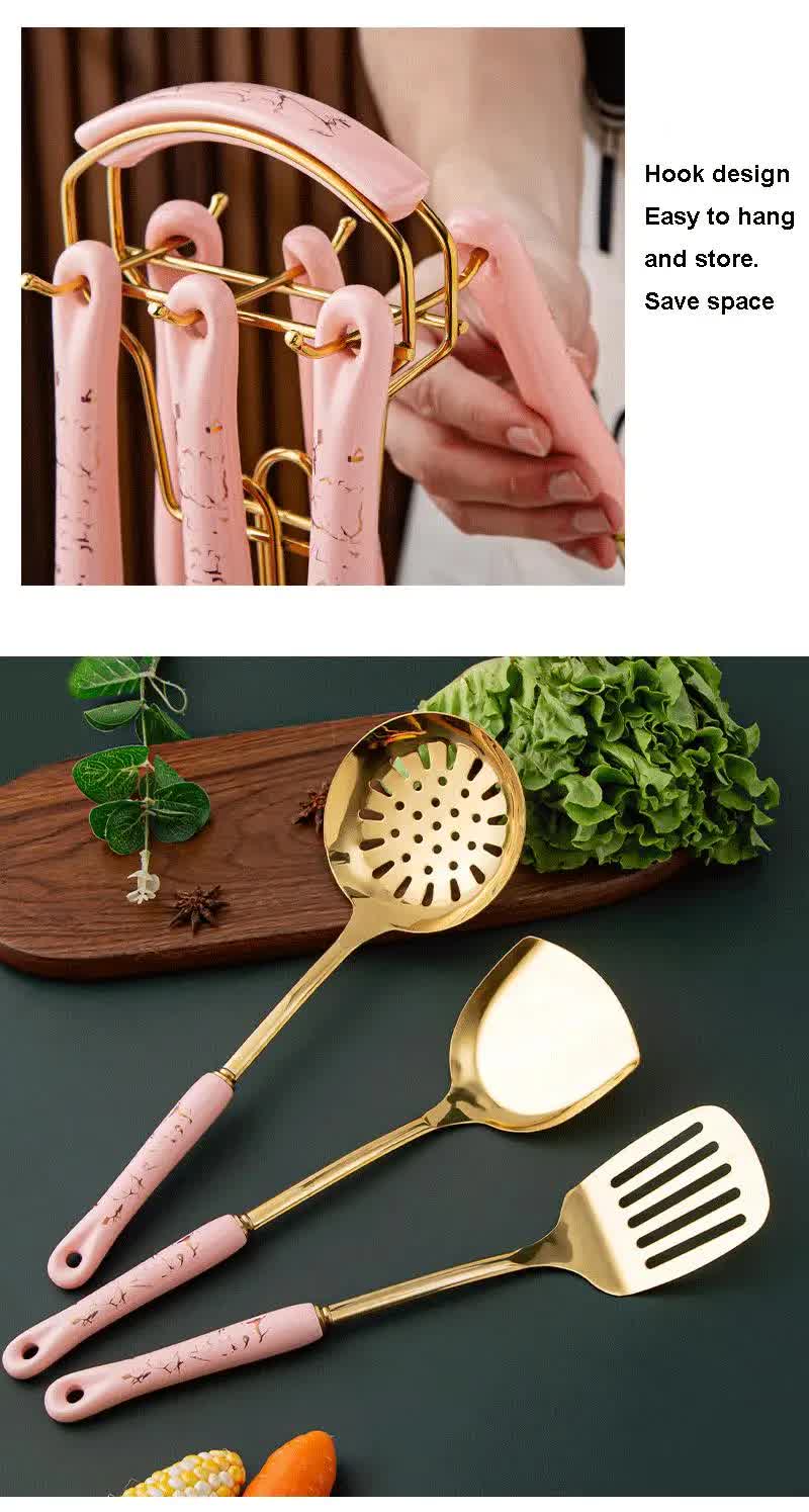 Set of pink and gold kitchen utensils with a hook design for storage.