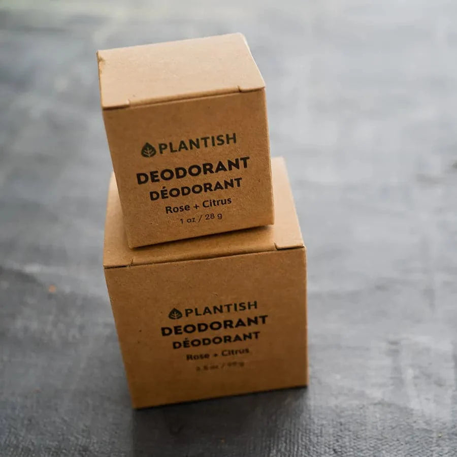 Two cardboard boxes of Plantish deodorant on a gray surface