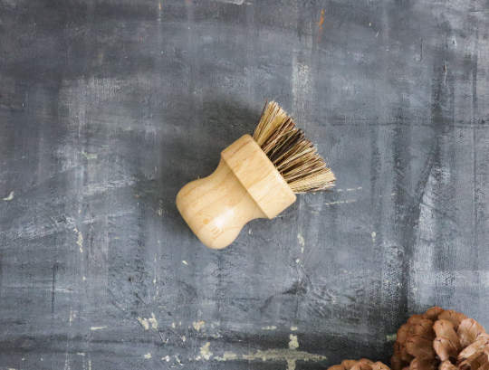 Wooden dish brush on a textured gray surface